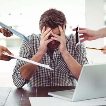 workplace-ptsd-man-at-desk-with-tasks-1200x800